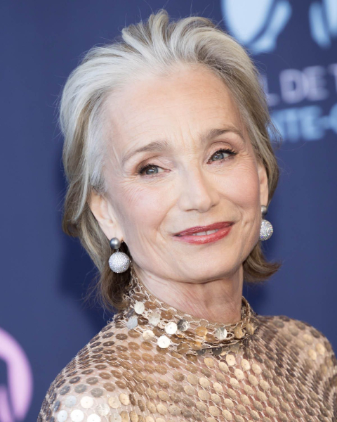 Kristin Scott Thomas smiling in a gold sequin dress