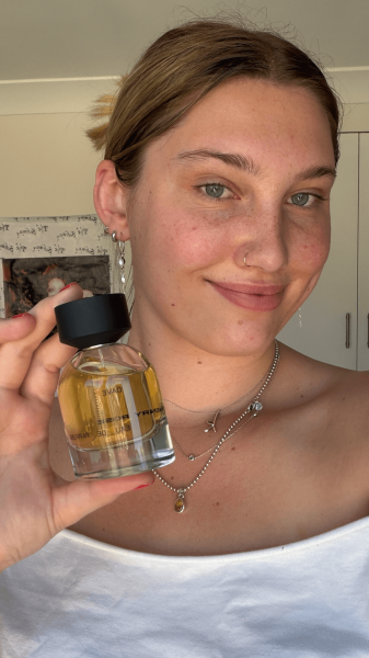 Allure associate social media manager Katie Gunderman with a bottle of the Henry Rose Dave Eau de Parfum