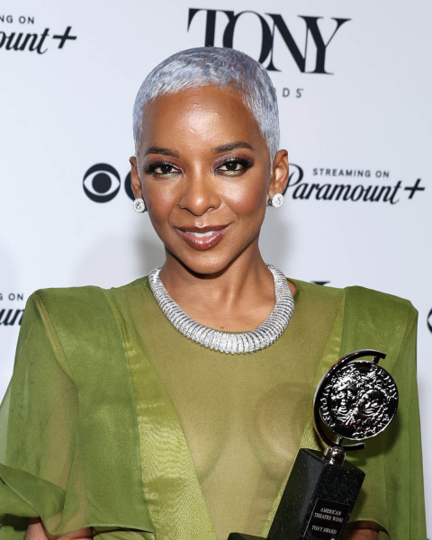 Kara Young with a silver pixie cut and wearing a sheer green dress